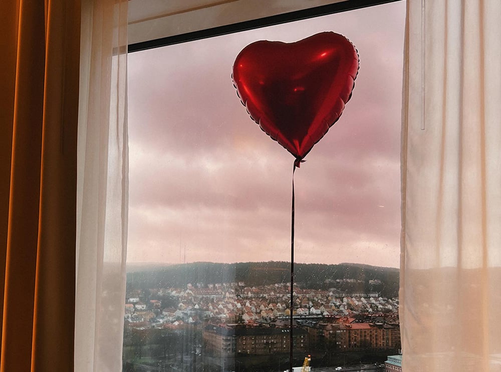 Heart shaped ballon in front of window