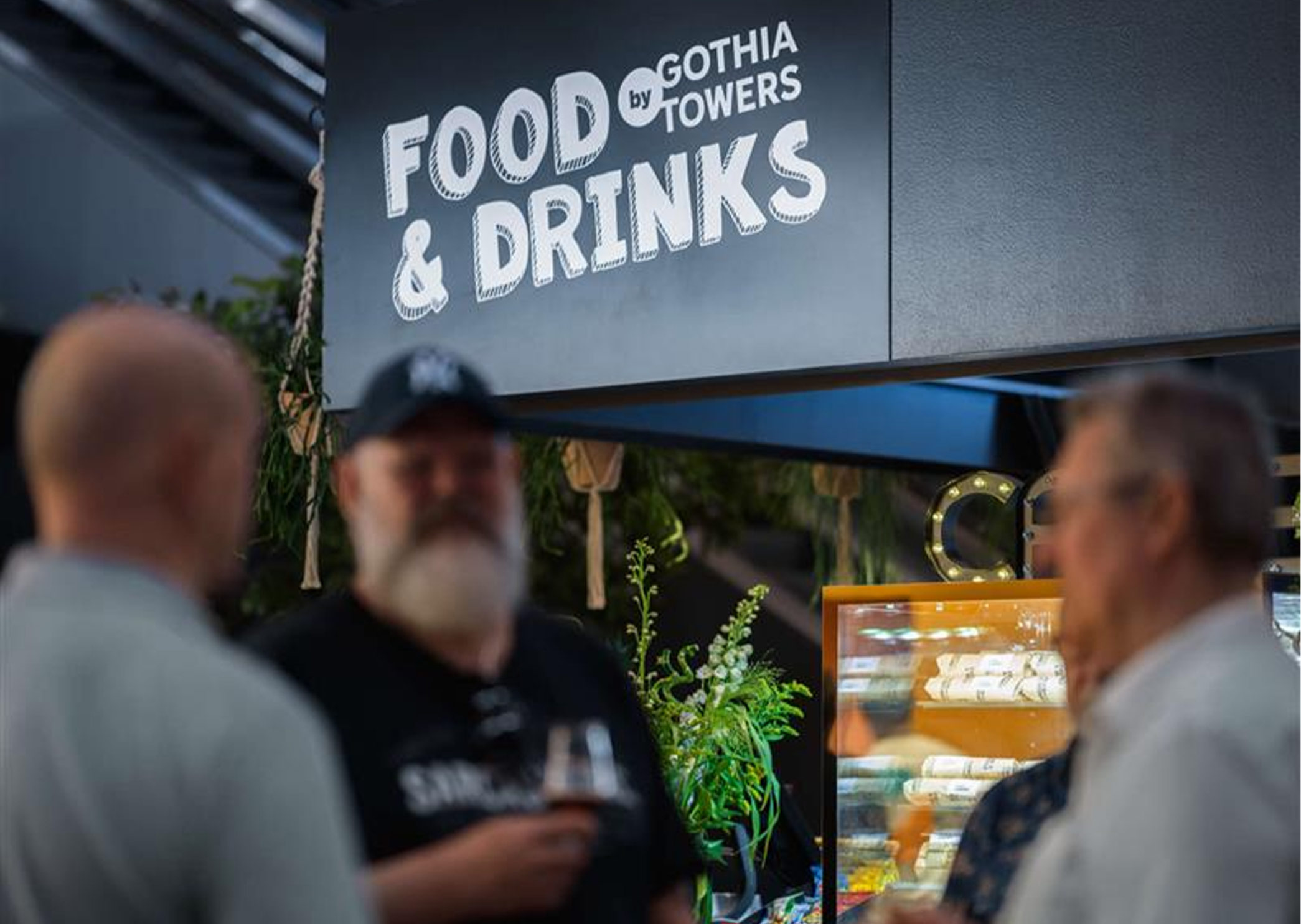 Food & Drinks area with visitors at an exhibition.