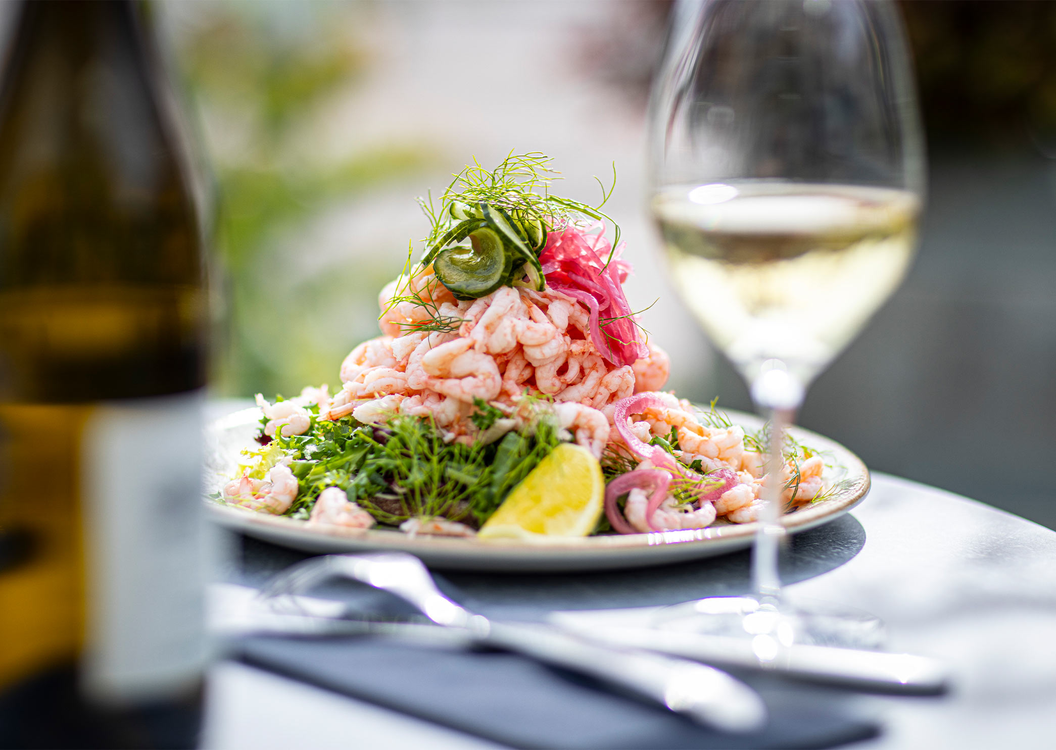King Size shrimp sandwich with hand-peeled shrimp, dill and lemon, served on a plate.